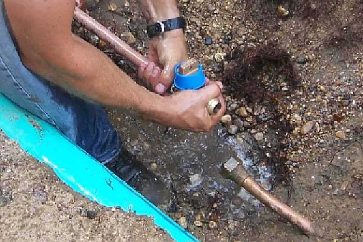 person working on buried pipes