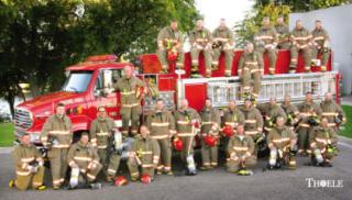 group of fire fighters in uniform in front of a firetruck